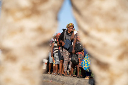 A Dominican Republic soldier keeps watch as Haitians queue while crossing the border after they were allowed into a market for needed essentials and trade, as gang violence continues in the aftermath of the resignation of Haiti's Prime Minister Ariel Henry, at a farmer's market in the border town of Dajabon, Dominican Republic, March 18, 2024. Photo by Fran Afonso/Reuters