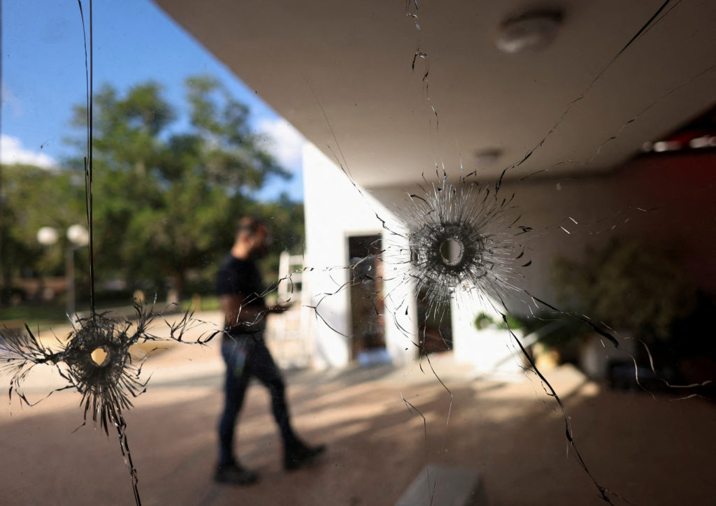 FILE PHOTO: A man walks behind a glass with bullet holes following the deadly October 7 attack by gunmen from Palestinian ...