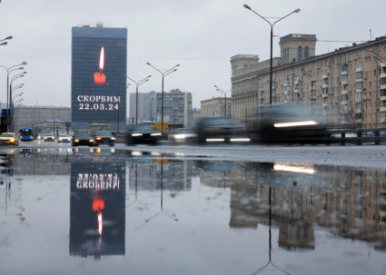 Cars drive past an electronic screen displaying the message "We mourn" in Moscow