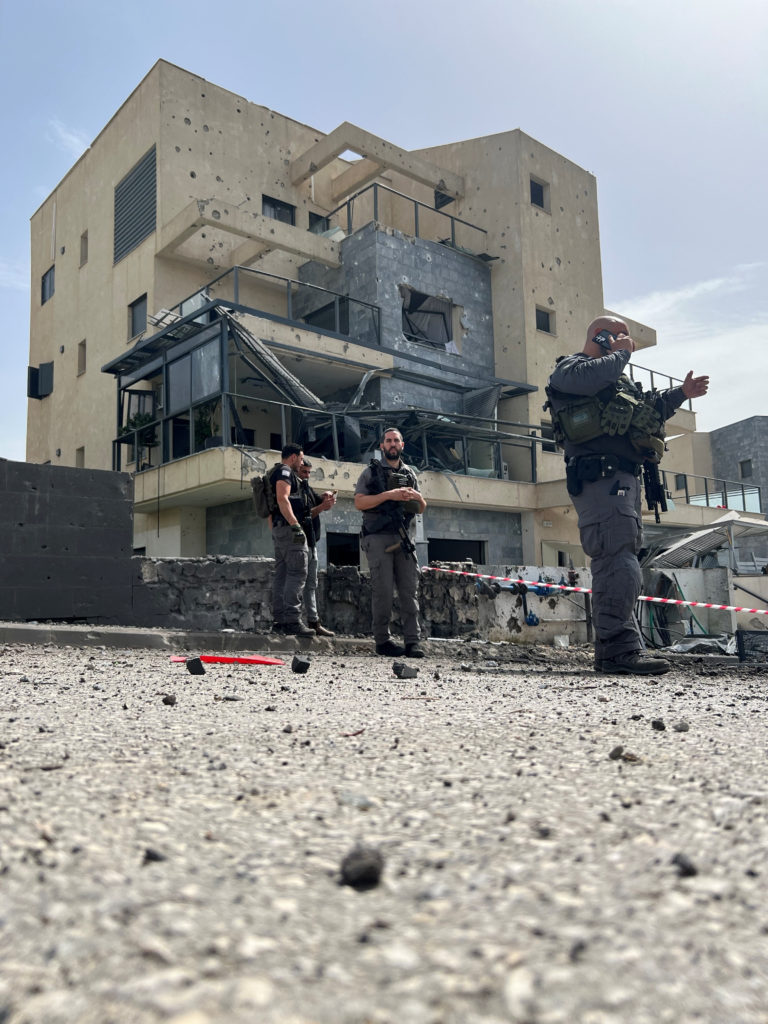Israeli police work at the site where a rocket landed after a lethal rocket strike on Israel, amid ongoing cross-border ho...