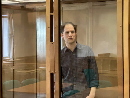 FILE PHOTO: Wall Street Journal reporter Evan Gershkovich stands behind a glass wall of an enclosure for defendants as he ...