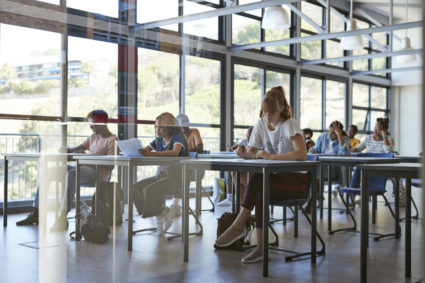 Young female and male students writing exam