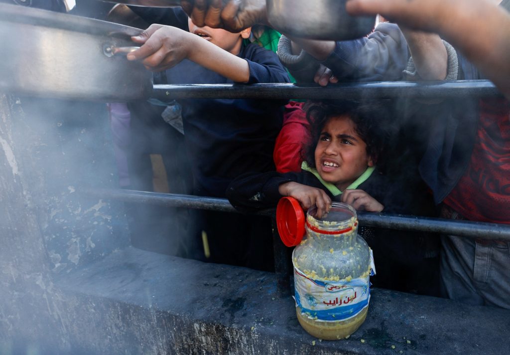 Palestinians wait to receive food during Ramadan, in Rafah