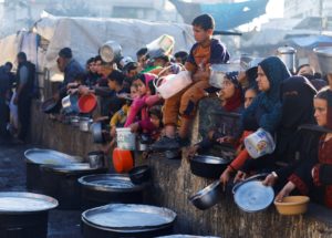 Palestinians wait to receive food during Ramadan, in Rafah