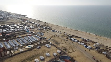 A drone view of Palestinians gathering on a beach in the hope of getting aid air-dropped over Gaza is seen, amid the ongoing the conflict between Israel and Hamas, in Deir Al-Balah in the central Gaza Strip February 26, 2024. Photo by Amjad Abu Sharia/Reuters