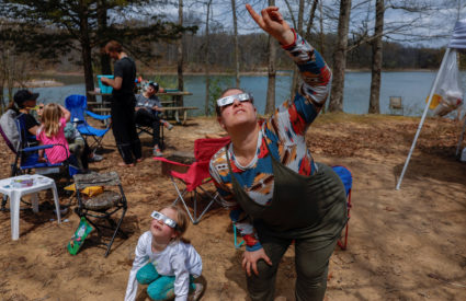 Campers try out solar eclipse glasses a day of ahead of the total solar eclipse in Southern Illinois
