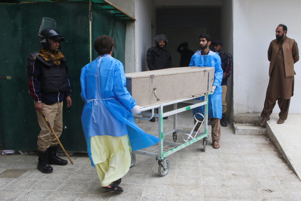 Paramedic staff move a coffin box, after gunmen shot and killed nine men after abducting them from a Iran-bound bus in Nos...