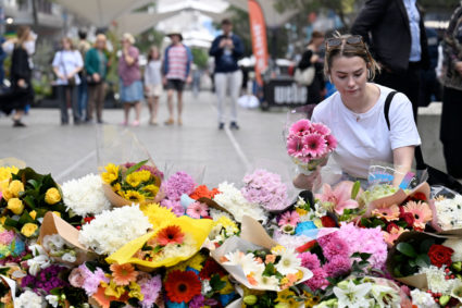 Members of the public pay their respect and lay flowers at the scene of Saturday's mass stabbing at Bondi Junction