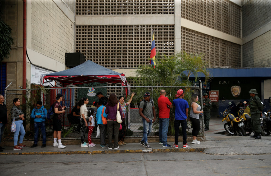 People stand in line to register to vote and to update their voting centres for the July 28 presidential elections, as the...