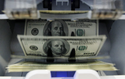Money counter counts 100 U.S. dollar banknotes in a bank in Bern