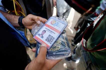 A person holds a document of aid worker Saifeddin Issam Ayad Abutaha, who was killed in an Israeli strike along with other...