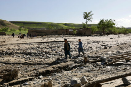 People walk amid mud and debris following a flash flood, in Burka District, Baghlan, Afghanistan, May 12, 2024. Photo by Sayed Hassib/Reuters