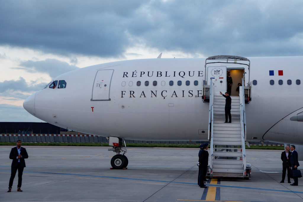 France's President Emmanuel Macron waves as he boards his Presidential plane to travel to the Pacific archipelago of New C...