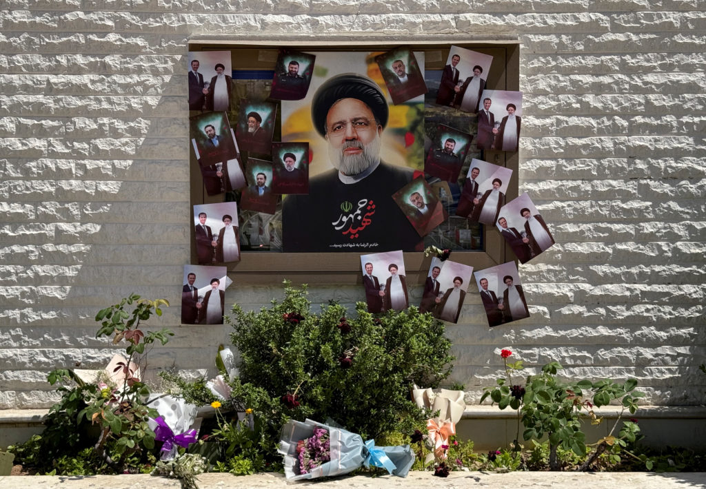 A poster depicting late Iranian President Ebrahim Raisi is seen among other pictures outside the Iranian embassy in Damascus