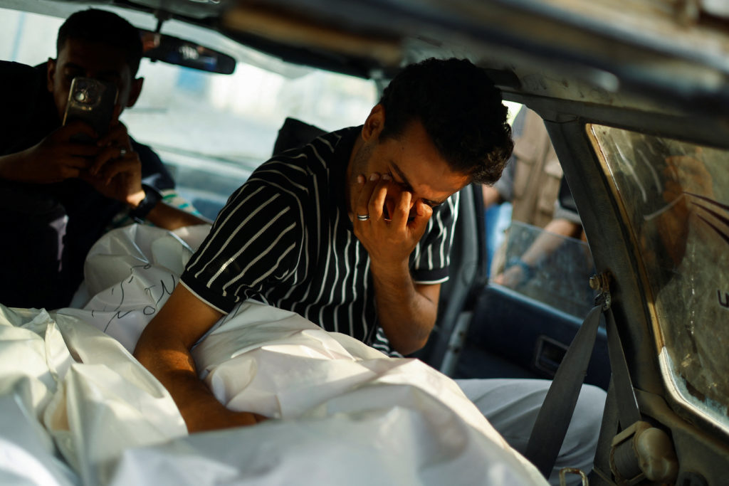A mourner reacts over the body of a Palestinian killed in an Israeli strike on an area designated for displaced people, du...