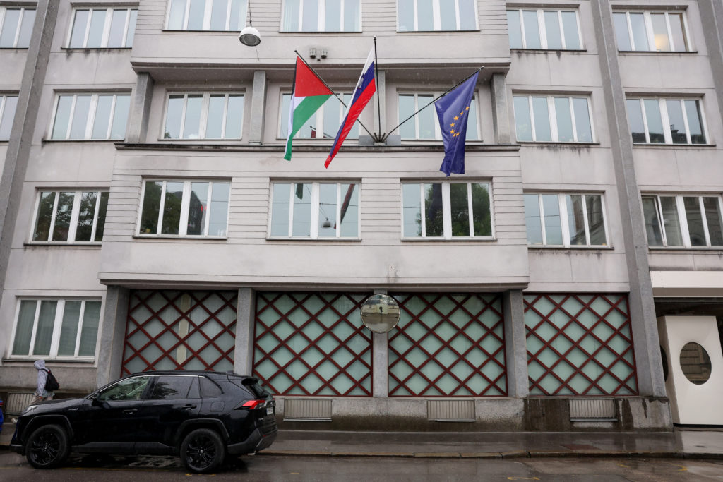 A Palestinian flag flies next to a Slovenian and a European Union flag, at the government building in Ljubljana, Slovenia ...