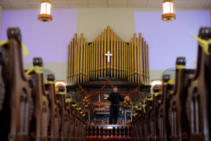 Pastor Kevin Gruver leads mass at Saint Paul's United Methodist Church, with aisles cordoned off to promote social distanc...