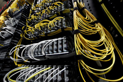 Cables run into the back of a server unit inside the data center of Equinix in Pantin, near Paris
