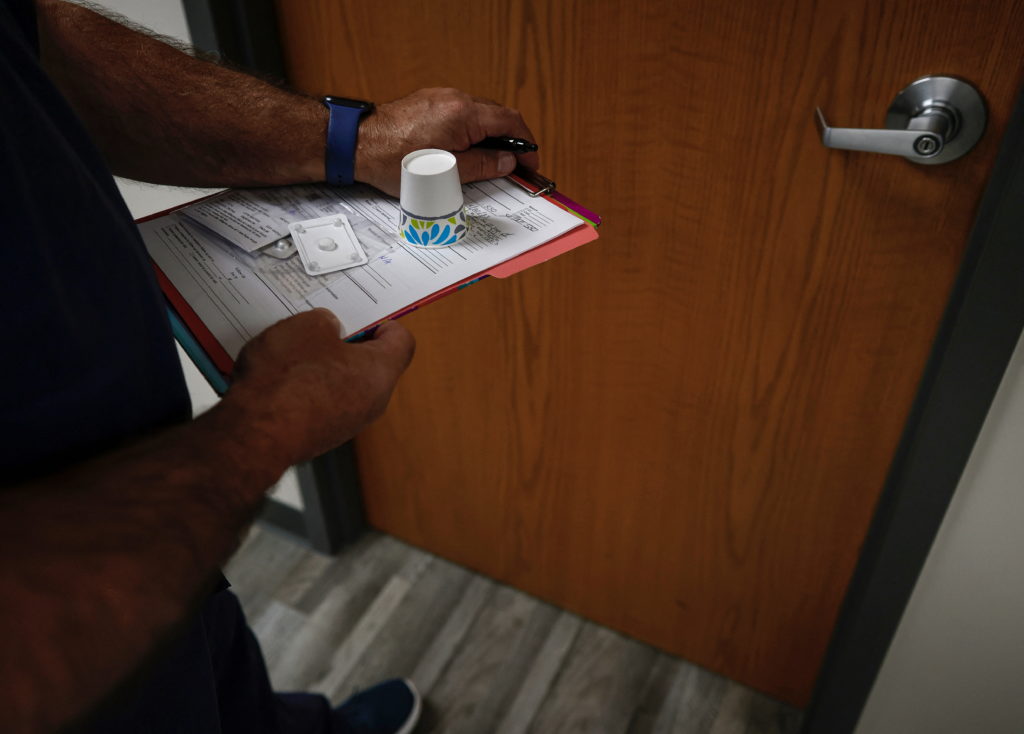 A doctor carries Mifepristone, the first pill in a medical abortion, to a patient waiting in an exam room at Alamo Women's...