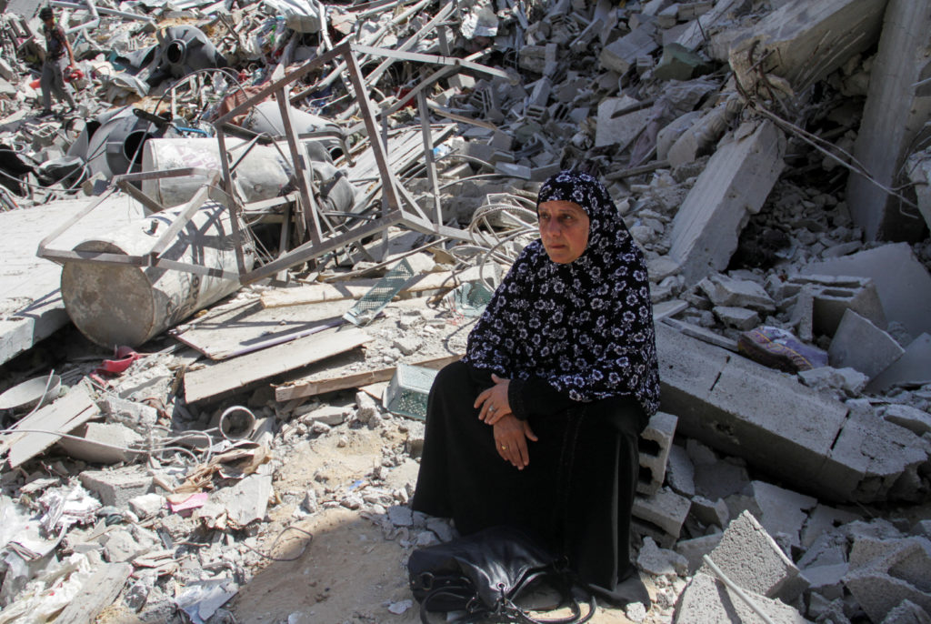 A woman sits on the rubble of a destroyed building, after Israeli forces withdrew from a part of Jabalia refugee camp, fol...