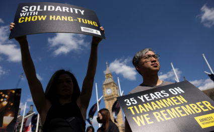 Demonstrators hold banners outside the parliament, marking the 35th anniversary of the Tiananmen Square crackdown in Beiji...