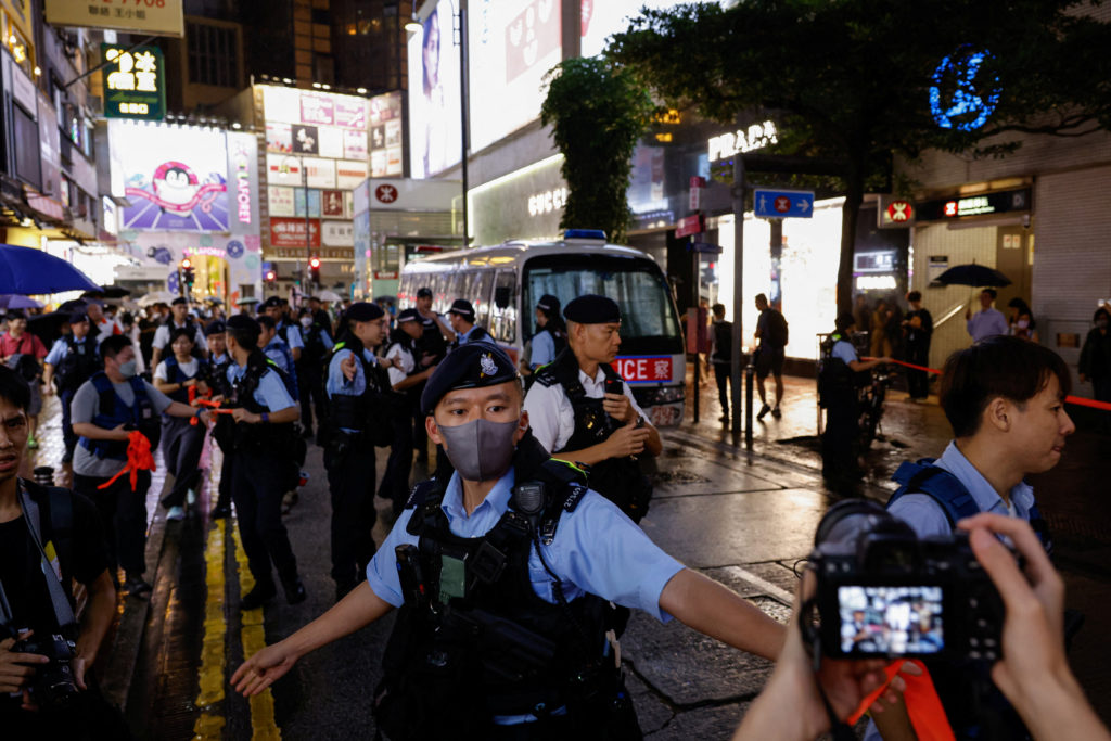 Police form a cordon as they detain performance artist Sanmu Chen in Hong Kong