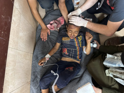 Wounded Palestinians injured in an Israeli strike on a UNRWA school at Al-Aqsa Martyrs Hospital