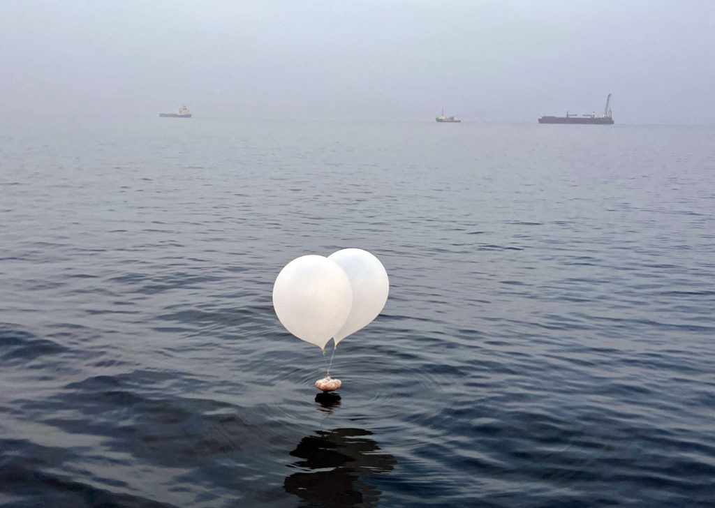 A balloon carrying various objects including what appeared to be trash, believed to have been sent by North Korea, is pict...