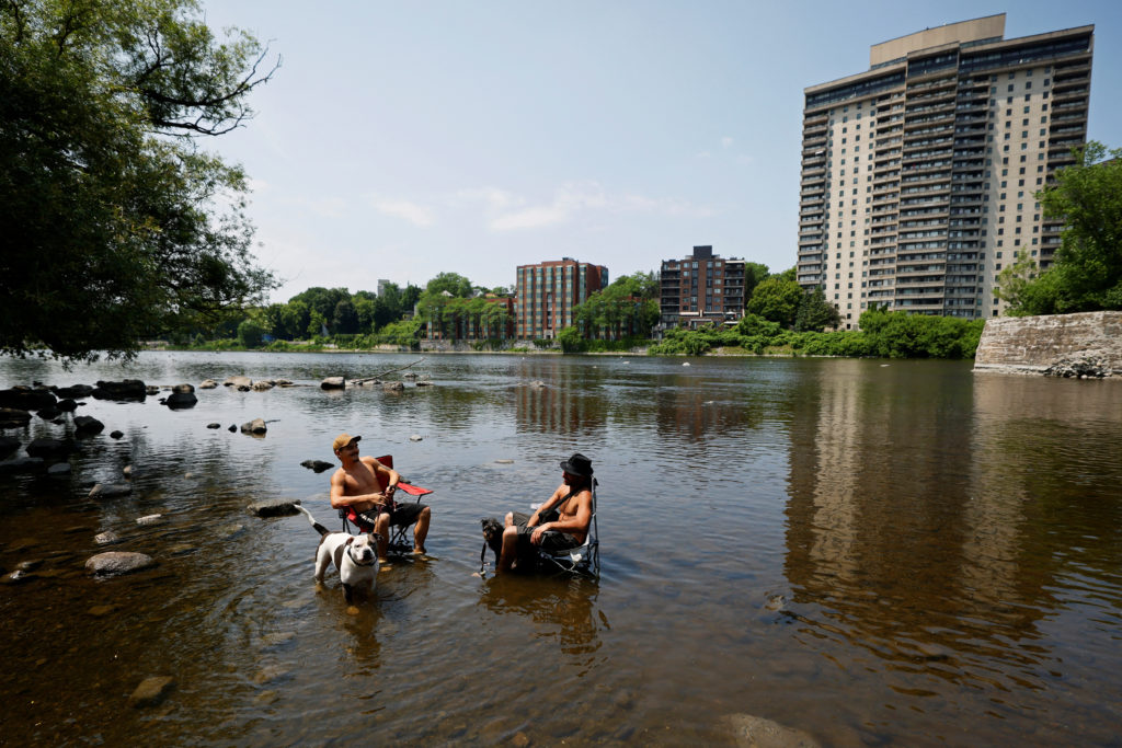 Taylor Fry and Christian Leardini of Bellissimo Roofing and Exteriors cool off in the Rideau River during a heat wave in O...