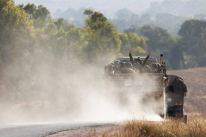 An Israeli soldier gestures from a truck carrying soldiers, amid the Israel-Hamas conflict, near the Israel-Gaza border