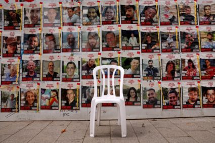 Chair is left in front of posters with pictures of hostages who were kidnapped during the deadly October 7 attack on Israe...