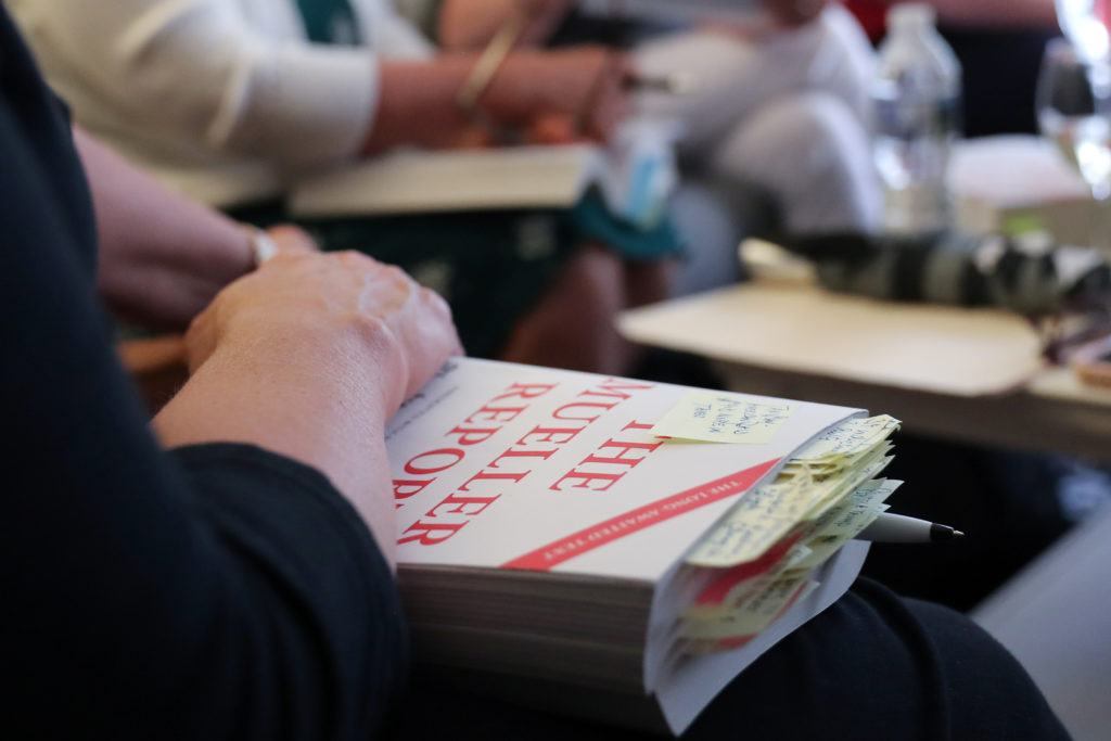 Book club member Wunder holds her copy of the Mueller Report with many notes and pages marked as she joins other book club...