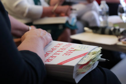Book club member Wunder holds her copy of the Mueller Report with many notes and pages marked as she joins other book club...