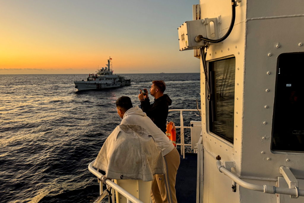 Philippine Coast Guard personnel documents a Chinese Coast Guard vessel shadowing the Philippine's resupply mission at Sec...