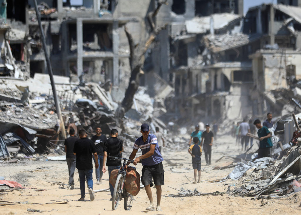 Palestinians inspect damage, after Israeli forces withdrew from Shejaiya neighborhood, in eastern part of Gaza city