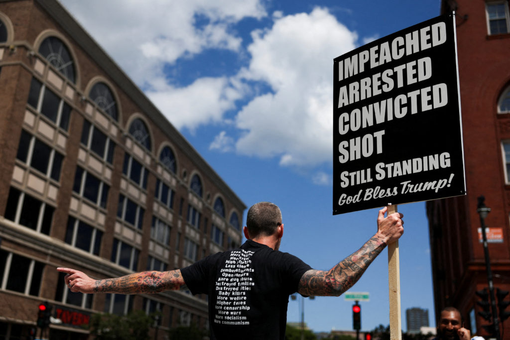 A man carries a placard in support of Republican presidential candidate and former U.S. President Donald Trump outside the...