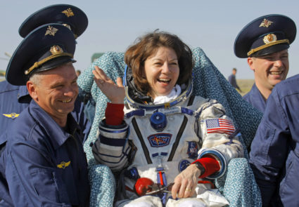 Ground personnel carry NASA astronaut Cady Coleman shortly after landing in the Soyuz TMA-20, southeast of Zhezkazgan
