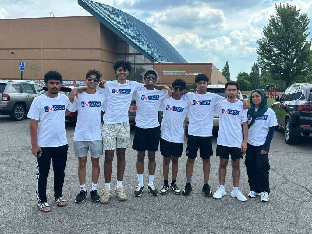 Group of Emgage volunteers stand arm in arm in front of Detroit recreation center before going out to talk to Muslim American voters in Detroit