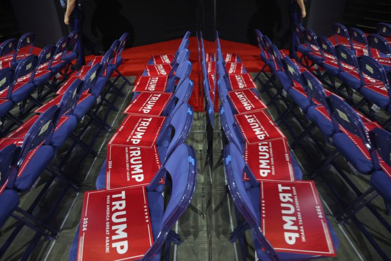 Staff place Trump signs on seats on Day 2 of the Republican National Convention (RNC) at the Fiserv Forum in Milwaukee