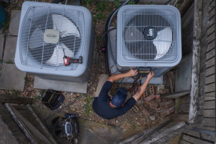 Repairman tests refrigerant in AC unit in Houston