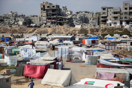Palestinians shelter in a tent camp as houses destroyed in Israeli strikes lie in ruins, amid the Israel-Hamas conflict, i...