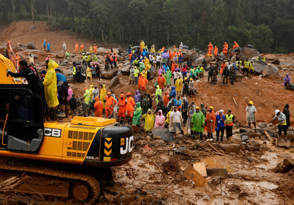 People watch as search operations are carried out after landslides hit Mundakkai village in Wayanad district in the southe...