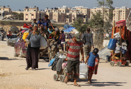 Displaced Palestinians make their way, as they flee Hamad City following an Israeli evacuation order, in Khan Younis