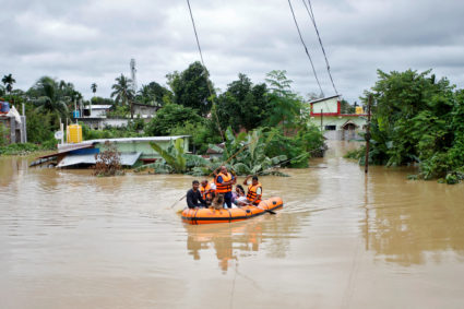 Rescuers from Tripura Disaster Management Authority evacuate flood-affected people to a safer place, on the outskirts of A...