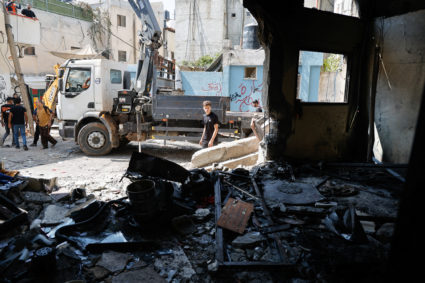 Palestinians inspect the damage following an Israeli military raid in Al-Faraa camp, near Tubas