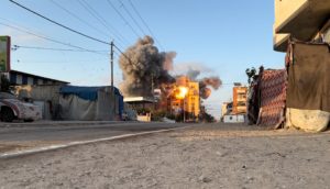 Smoke and flames rise following an Israeli strike on a residential building inNuseirat in the central Gaza Strip