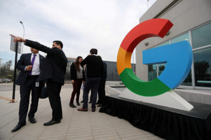 FILE PHOTO: People gather next to a Google logo during the announcement of the plans for their data centre expansion in Sa...