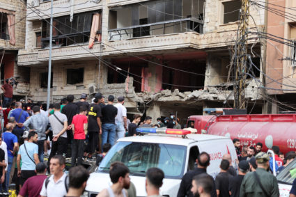 People inspect the site of an Israeli strike, in Beirut
