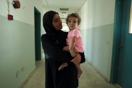 Rima Ali Chahine holds her granddaughter Matilda, in a hallway of the Technical Institute of Bir Hassan which has been tur...
