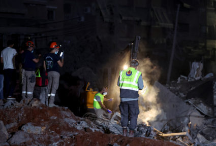 People inspect damage at the site of an Israeli strike, in Beirut